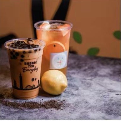 Boba milk tea and citrus fruit tea on the counter at Tea Plus Tea Bar