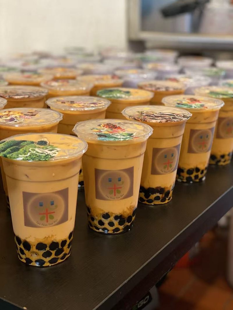Rows of Thai milk tea with boba, ready for pickup