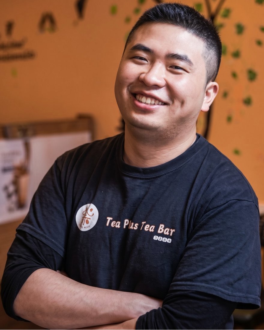 The owner of Tea Plus Tea Bar, smiling in the shop